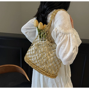 Detail of woven metallic gold mesh tote bag with inner white pouch for beach vacation