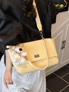 Minimalist light yellow pebble leather shoulder bag with cute plush puppy charm