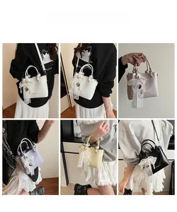 Détails du sac seau tendance avec nœud en dentelle, chaîne en perles et pendentif cœur