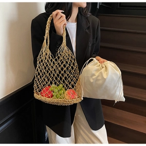 Detail of gold woven mesh handbag featuring a cream drawstring liner and fruit inside