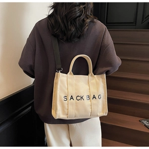 Detailed close-up of large canvas tote bag with SACKBAG logo and black shoulder strap