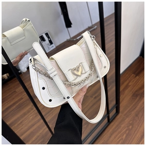 Detail of white faux leather underarm bag with stone texture and heart metal buckle