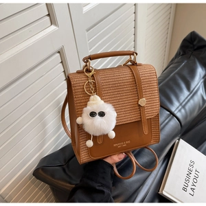 Brown woven texture backpack with metal buckle and cute monster plush pendant detail