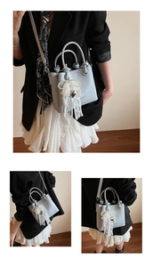 Détail du sac seau bleu clair avec pendentif décoratif en perles et cœur en dentelle