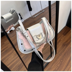Detail of silver and pink stone pattern shoulder bag with a gold heart buckle