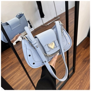 Detail of light blue faux crocodile skin bag with silver heart buckle and chain strap