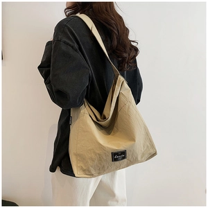 Detail shot of the durable khaki nylon material and brand logo on this large tote bag