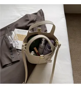Spacious interior of beige lychee leather bucket bag with phone, cosmetics and umbrella
