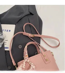 Pink lychee grain leather bucket bag with silk scarf handle and golden hardware