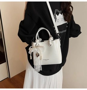 Sac seau plissé blanc chic avec nœud en dentelle et perles porté par un mannequin