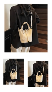 Detail of lychee pattern leather bucket bag with gold lock and smiley pendant