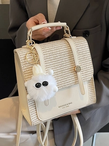 Elegant beige straw and faux leather handbag with plush charm and top handle