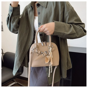 Beige lychee pattern leather shell bag with silver hardware and braided rope charm