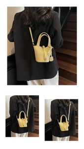 Detail of yellow lychee texture leather bucket bag with silver padlock and shoulder strap