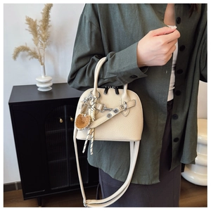 Close-up of a cream shell bag with lychee texture and silver hardware details
