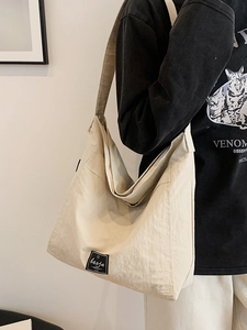 Minimalist beige oversized tote bag in casual canvas with adjustable shoulder strap