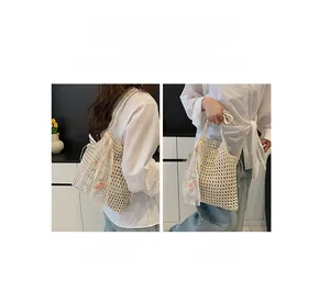 Detail of hand-woven tote bag with 3D floral embroidery and lace trim details