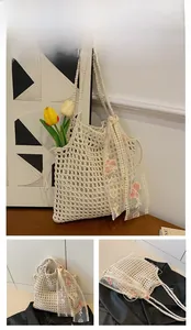 Detailed close-up of ivory crochet tote bag featuring delicate pink floral lace embroidery
