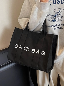 Large black canvas tote bag with white lettering for stylish commuting and casual travel