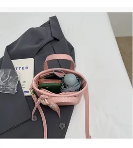 Pink bucket bag interior view showing storage space for phone, wallet, and mini umbrella
