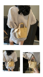 Detail of beige litchi grain bucket bag with silk scarf handle and long shoulder strap