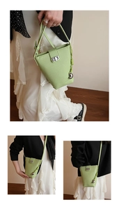 Détails du sac seau vert clair avec fermoir rotatif argenté et pendentif coeur élégant