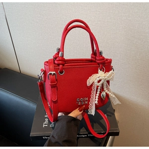 Detail of red lychee pattern bucket bag with pearl lace bow and heart metal pendant