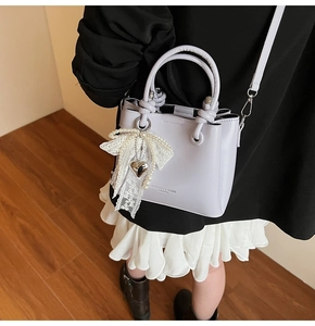 Détail du sac seau lavande avec breloque en dentelle de perles et imprimé mode