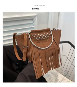 Dettaglio della borsa a secchiello marrone con borchie, manico ad anello e lunghe frange