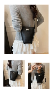 Détails du sac seau noir en cuir grainé avec fermoir rotatif argenté et bandoulière