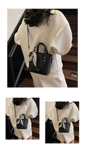 Detail of black lychee grain mini tote bag with silk scarf on handle and shoulder strap