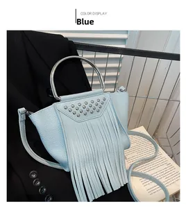 Dettaglio della borsa a tracolla azzurra con lunghe frange e borchie argentate sulla patta