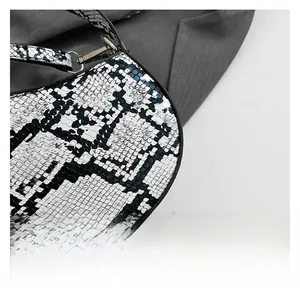 Close-up of black and white snakeskin texture and leather edge finish on underarm bag