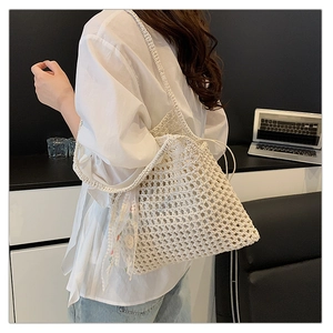 Detail of crochet tote bag with open-knit texture and floral lace ribbon accessory