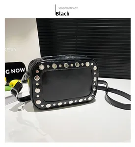 Detail van zwarte lederen crossbodytas met zilveren studs en gepolijste metalen finish