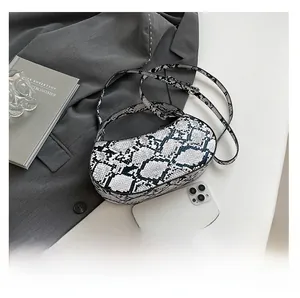 Detailed view of mini python print crescent bag with phone shown for scale reference