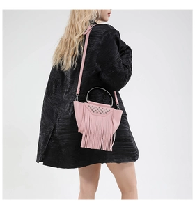 Borsa a secchiello in pelle rosa con borchie argento e frange lunghe indossata da modella