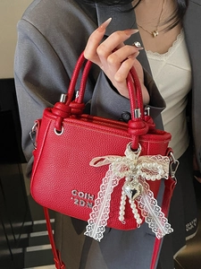 Red lychee grain leather bucket bag with pearl lace bow charm and adjustable strap