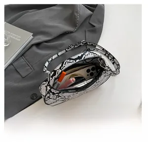 Detail view of snakeskin pattern bag interior showing capacity for phone and makeup