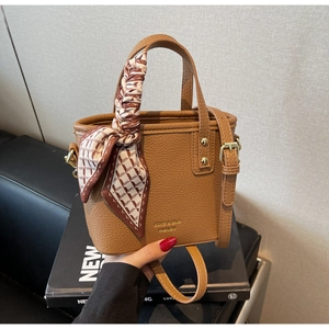 Brown litchi grain bucket bag with decorative silk scarf on handle and shoulder strap
