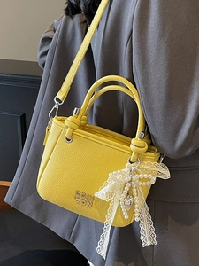 Litchi texture yellow leather bucket bag with knotted handles and pearl bow charm