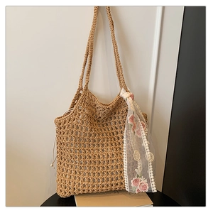 Detail of hand-woven beige tote bag with floral lace scarf and drawstring liner