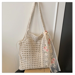 Detail of hand-woven crochet shoulder bag with floral lace scarf and mesh texture