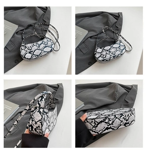 Detail view of stylish black and white snakeskin crescent bag from multiple angles