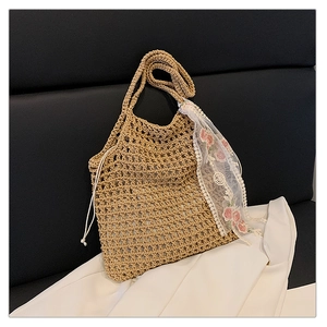 Detail of hand-woven crochet straw bag with pink rose embroidery on white lace ribbon