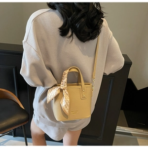 Chic apricot lychee pattern bucket bag with silk scarf handle detail and gold logo