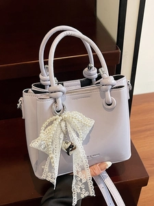 Sac seau en cuir lilas minimaliste avec nœud en dentelle et poignée à nœud