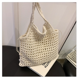 Close-up of cream woven mesh beach bag with drawstring closure and hollow crochet detail