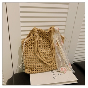 Detail of hand-woven straw tote bag featuring hollow crochet texture and lace scarf accent