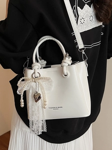 Sac seau chic en cuir blanc brillant avec poignée nouée et breloque en perles